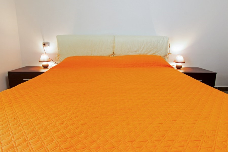 Letto con coperta arancione